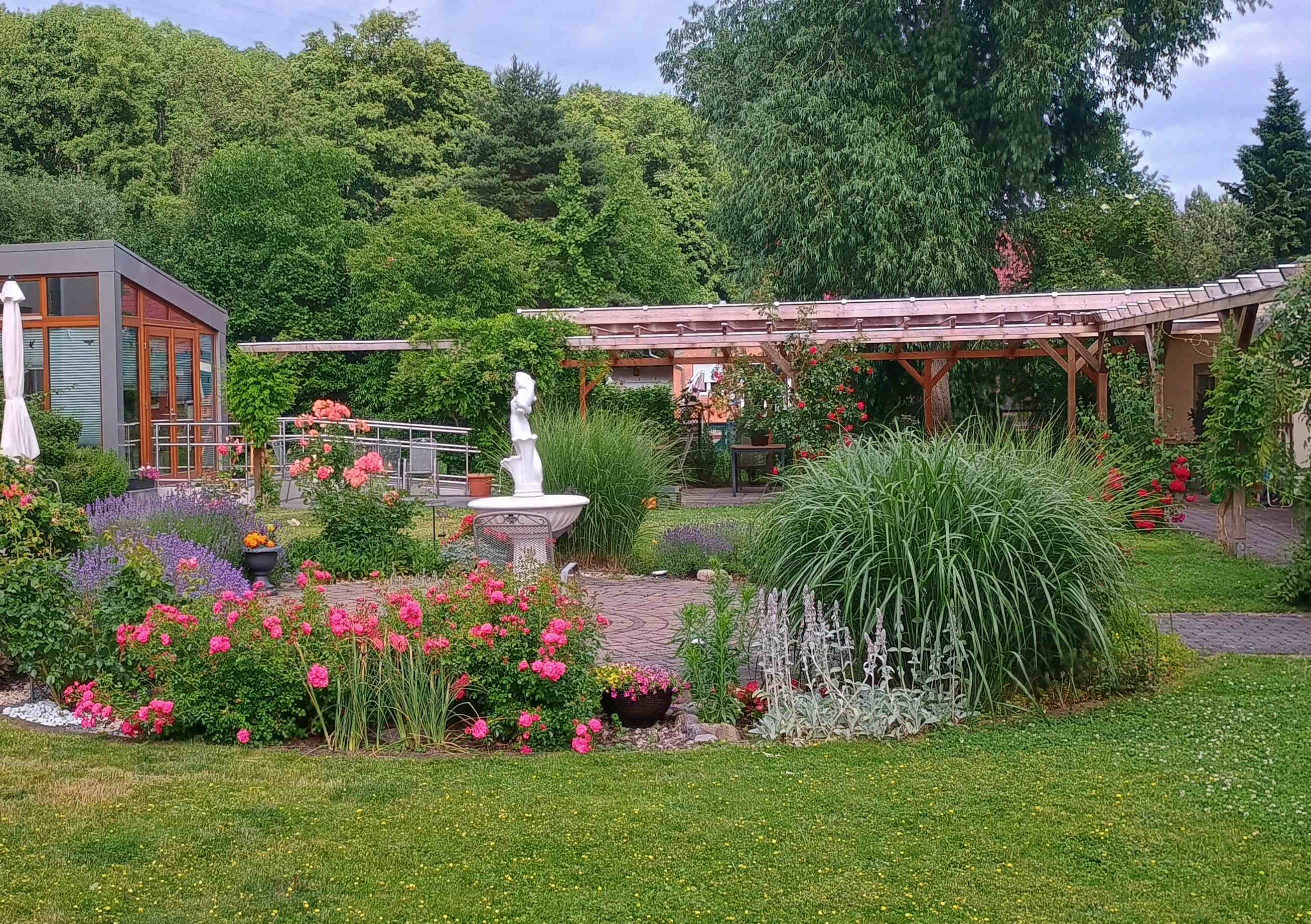 Gartenmitte mit Wintergarten im Hintergrund